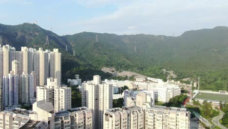 mega residential buildings in downtown hong kong and lion rock mountain ridge in the background, aerial view