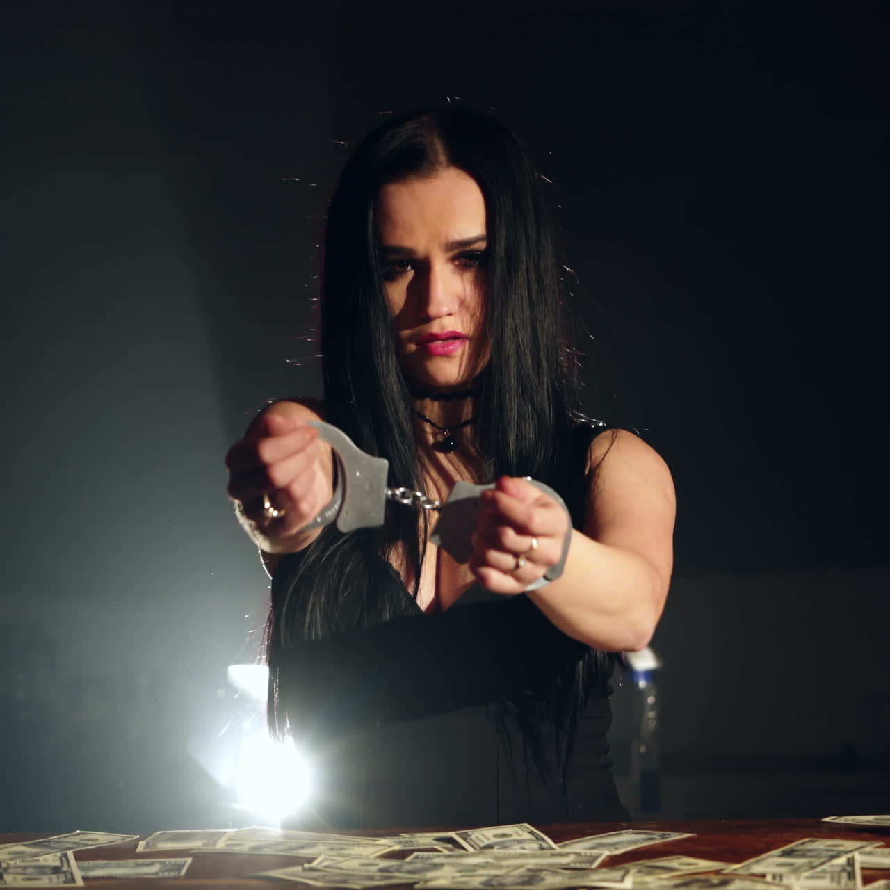 Beautiful brunette woman in handcuffs trying to free herself. Prisoner or arrested terrorist