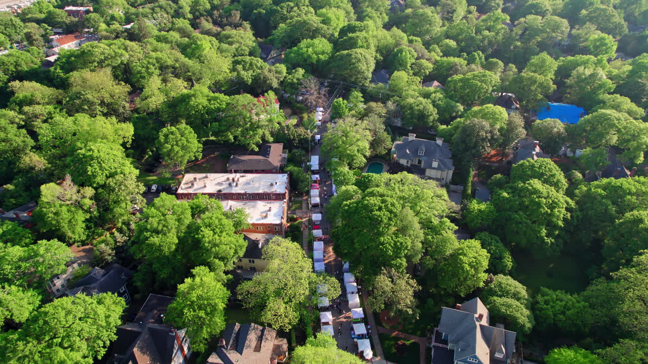 Ripresa aerea dinamica sulle tende dei venditori locali all'Inman Park Festival, un popolare evento primaverile in uno storico quartiere di Atlanta, in Georgia, con una vivace area urbana alberata e parchi e strade panoramiche