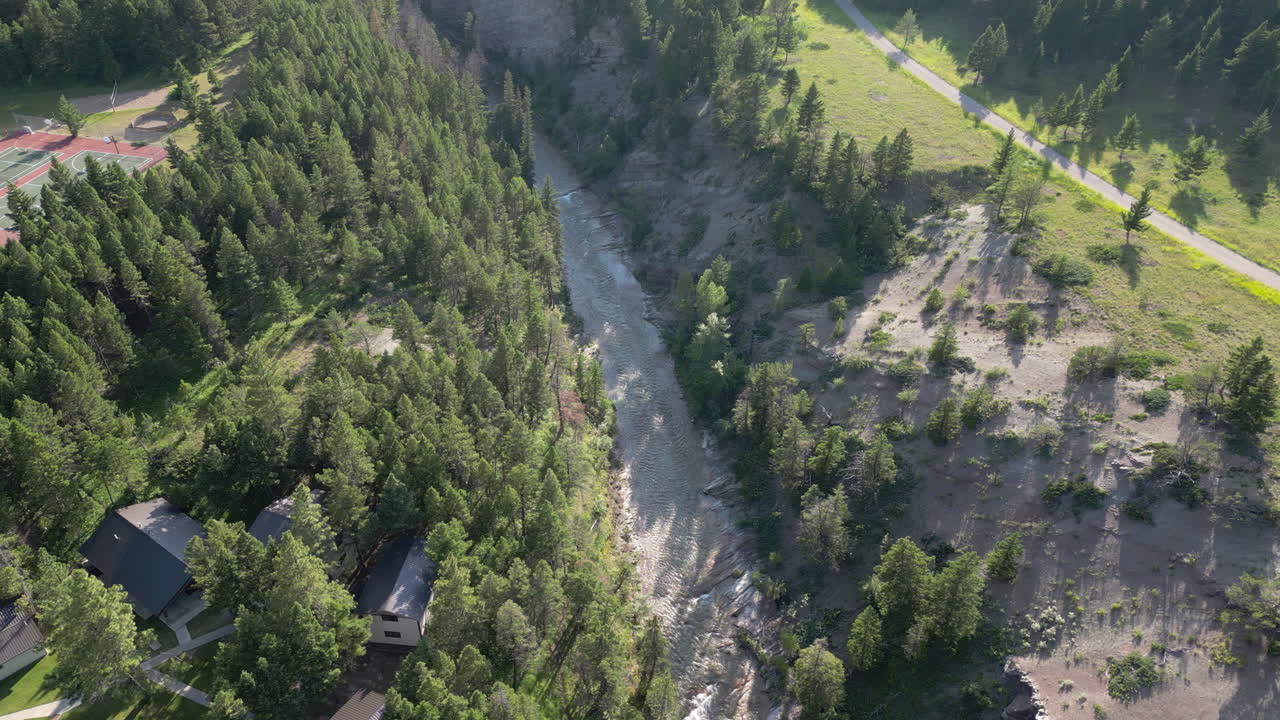 río al lado del campamento de verano se extiende hasta el bosque de hoja perenne con montañas en silueta