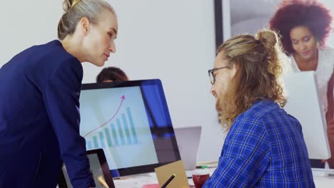 Executives-interacting-with-each-other-while-working-at-desk-4k