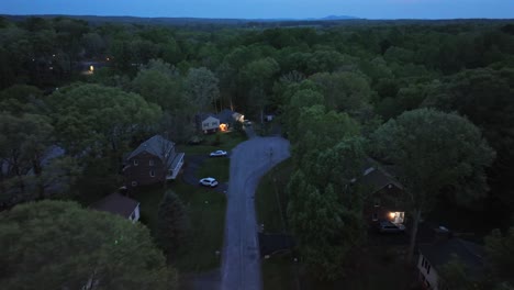 cul-du-sac of american forest landscape in suburbia. spring evening at dusk. parking cars at american neighborhood. aerial wide shot. calm and peaceful