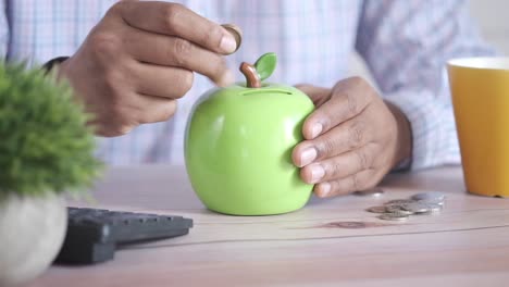 person saving money in a piggy bank