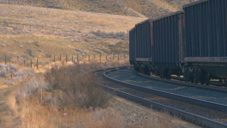 Train-coal-cars-are-passing-by-in-the-outskirts-of-Kamloops,-British-Columbia