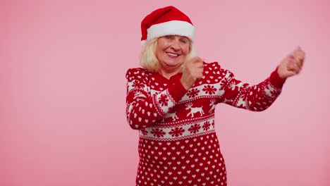 senior christmas old grandmother woman listening music via earphones dancing disco fooling around