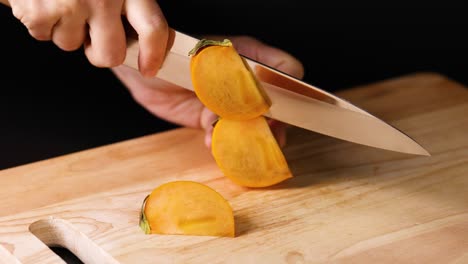 hands carefully slicing a persimmon with knife