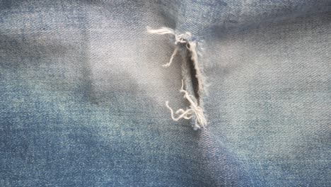 close up of torn blue jeans