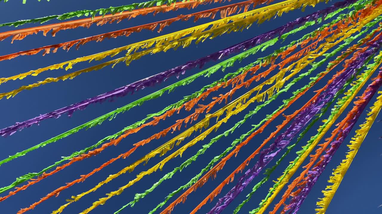 파란 하늘 앞의 거리를 장식하는 다채로운 리본. 휴가 개념.