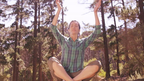 la mujer está haciendo yoga en el bosque.