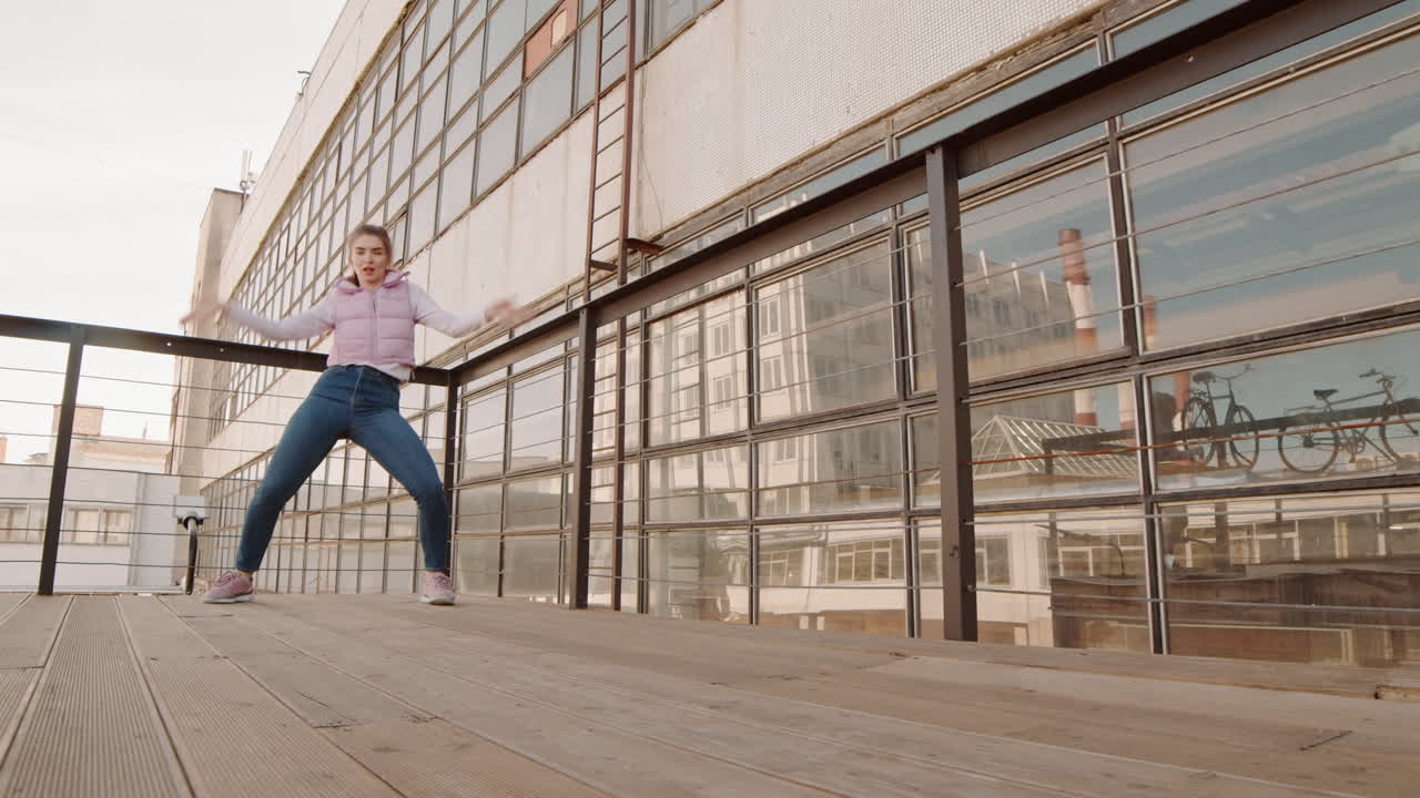Young Woman Dancing by Industrial Building