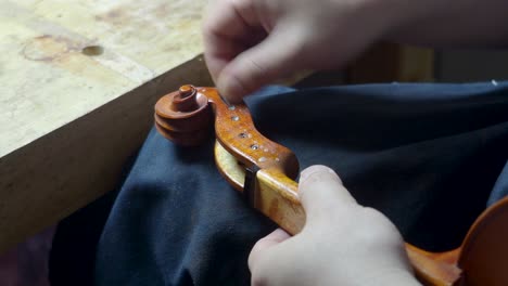 maestro artesano luthier fabricante de violín anticuado violín rizado y caja de clavos con tela y aceite cáustico ácido en nuevo instrumento de cuerda para reproducir la obra maestra original angustia