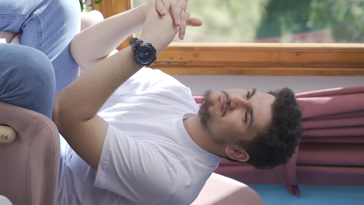 video vertical de en la ventana el hombre está soñando despierto y riendo.