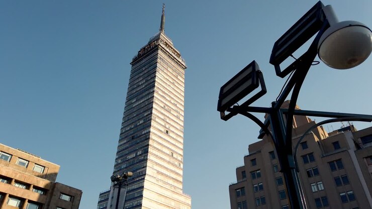 Torre Latinoamericana alta se elevando entre os edifícios ao redor em um dia claro