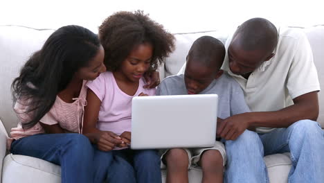 Familia-Mirando-La-Computadora-Portátil-En-El-Sofá