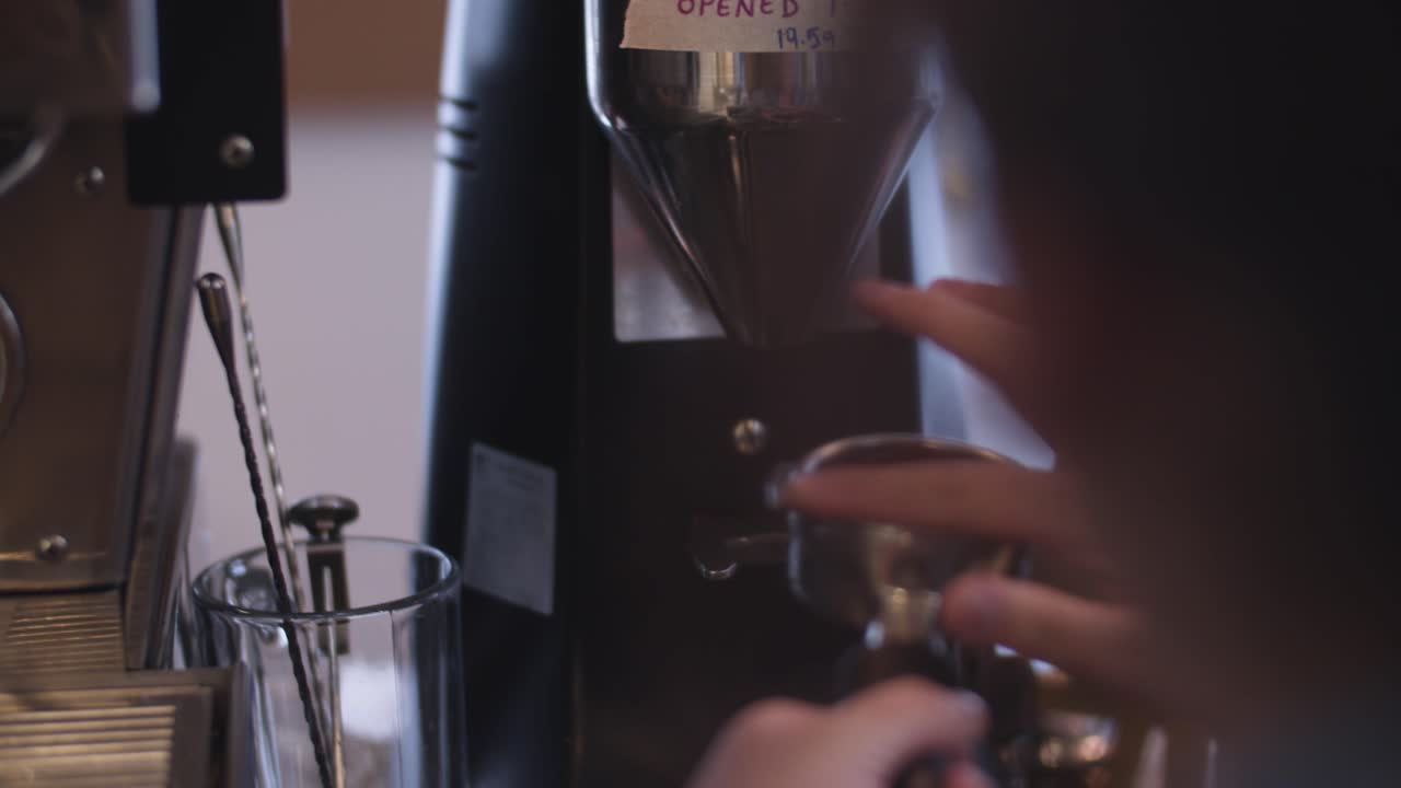 바리스타가 커피를 갈아서 샷을 포장합니다.