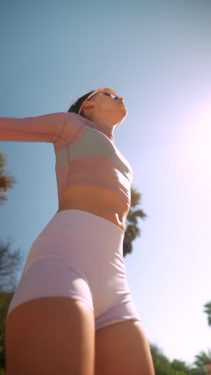 Giovane donna che fa stretching all'aperto in una giornata di sole