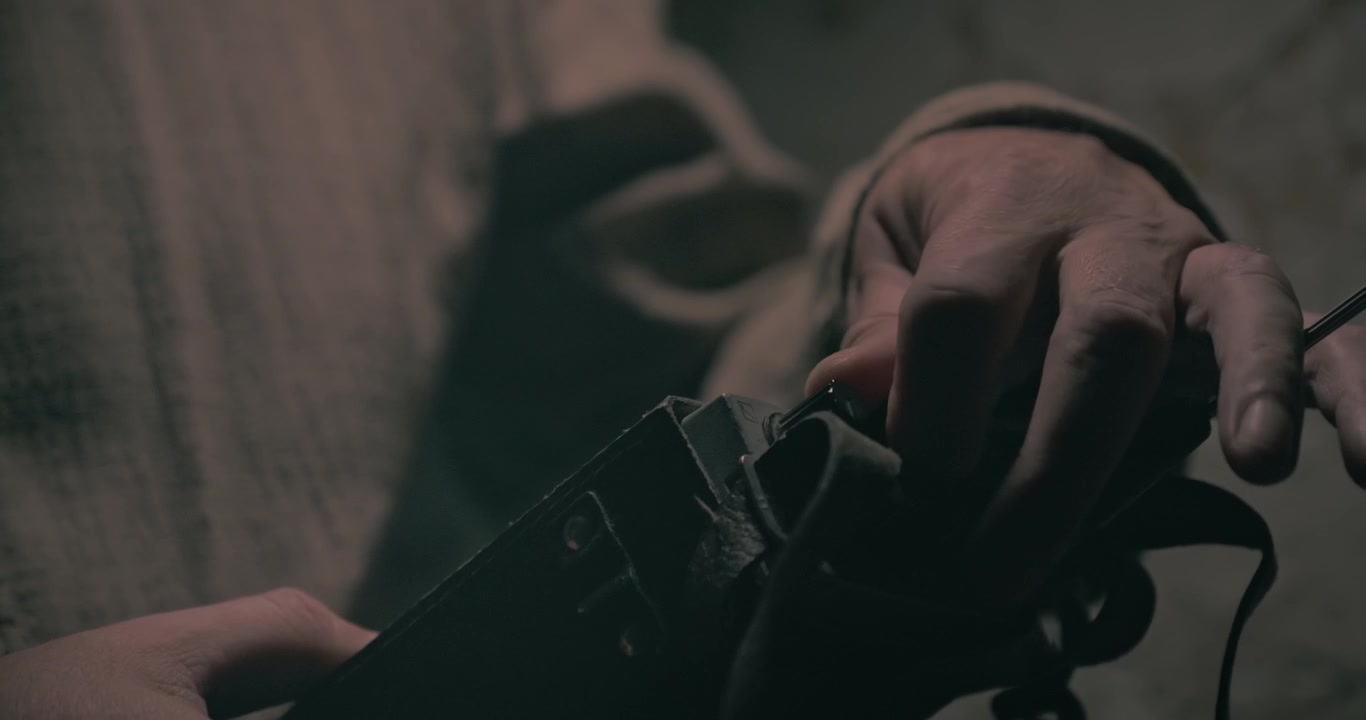 Close-up shows communications personnel using a vintage radio set inside a wartime bunker with low cinematic lighting and an atmospheric mood.