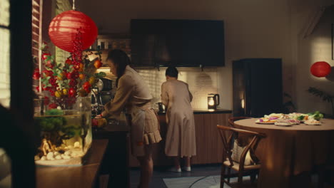 a woman and a man working together in the kitchen, preparing food with care