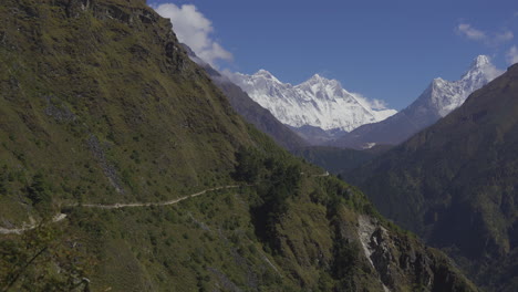 stunning trekker's view of the dingboche to thukla pass route, with ama dablam in the background, clear blue sky, hills, and blue mountains along the way to everest base camp trekking trails on hills