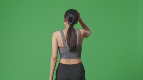 woman in sportswear back view on green screen