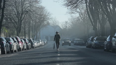 Woman-walks-in-the-middle-of-road-as-car-follows-her