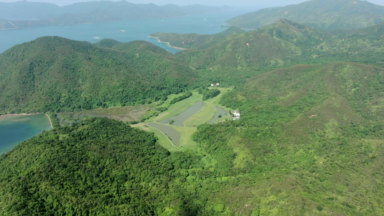 무성한 녹색 산악 지형이 있는 홍콩만의 공중 전망