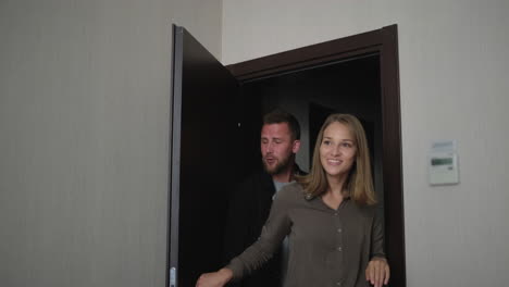 una pareja hablando dentro de la puerta de un apartamento.