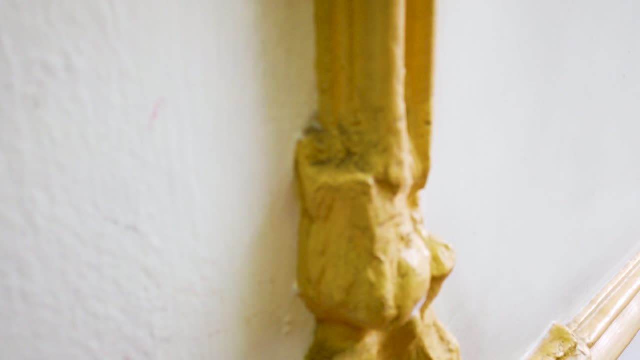 Close-up shot of plaster framing resembling wooden moldings, prepared to receive gold leaf treatment, inside a School of Architecture in Mexico City