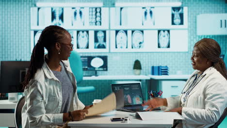 african american woman doctor explaining radiology results to a girl
