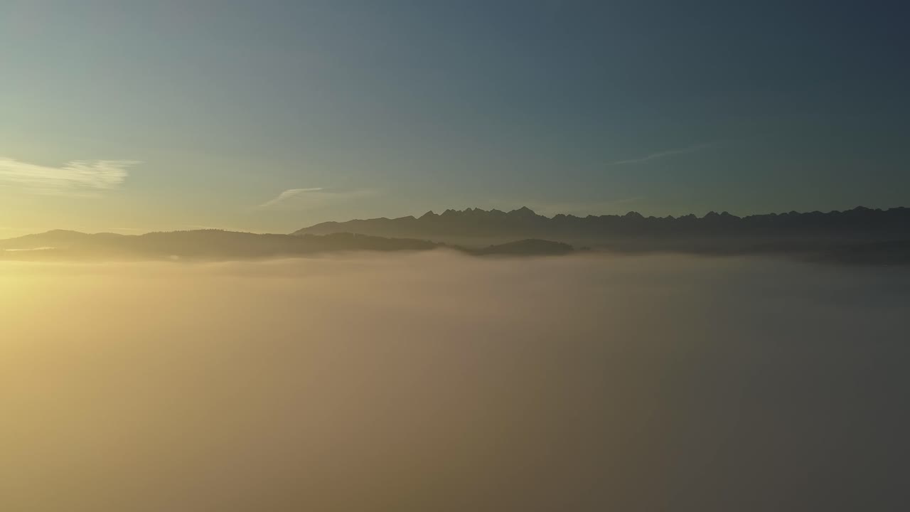 멀리 산봉우리가 있는 다채로운 일출 동안 안개 위의 공중