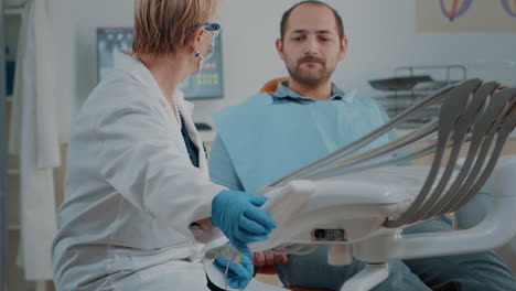 mature dentist examining patient with caries and toothache