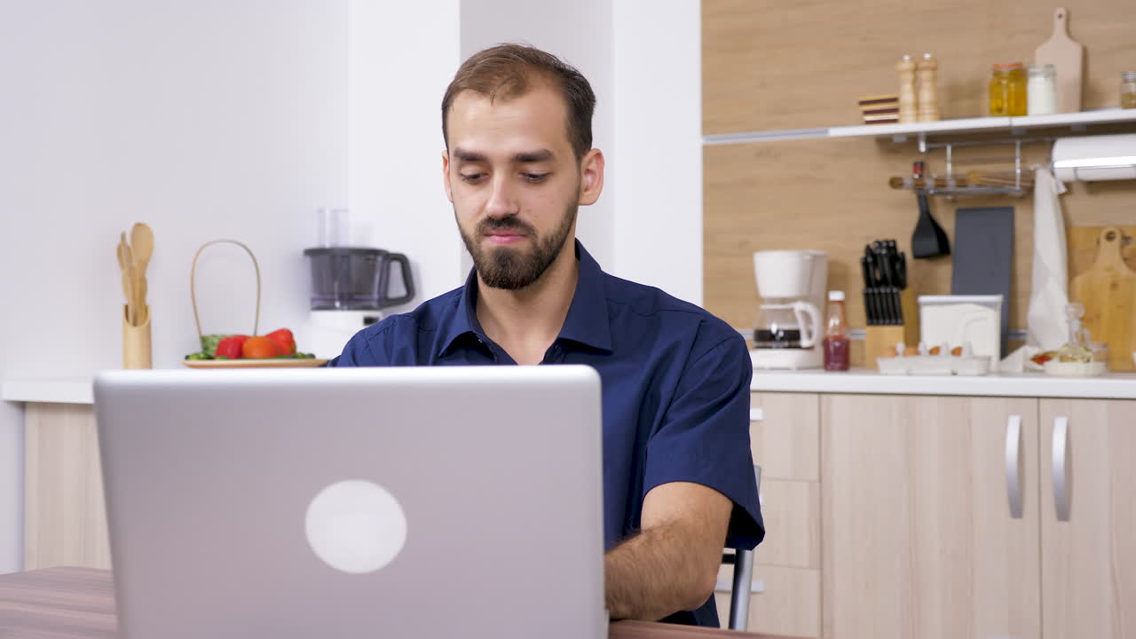 Man using laptop in kitchen