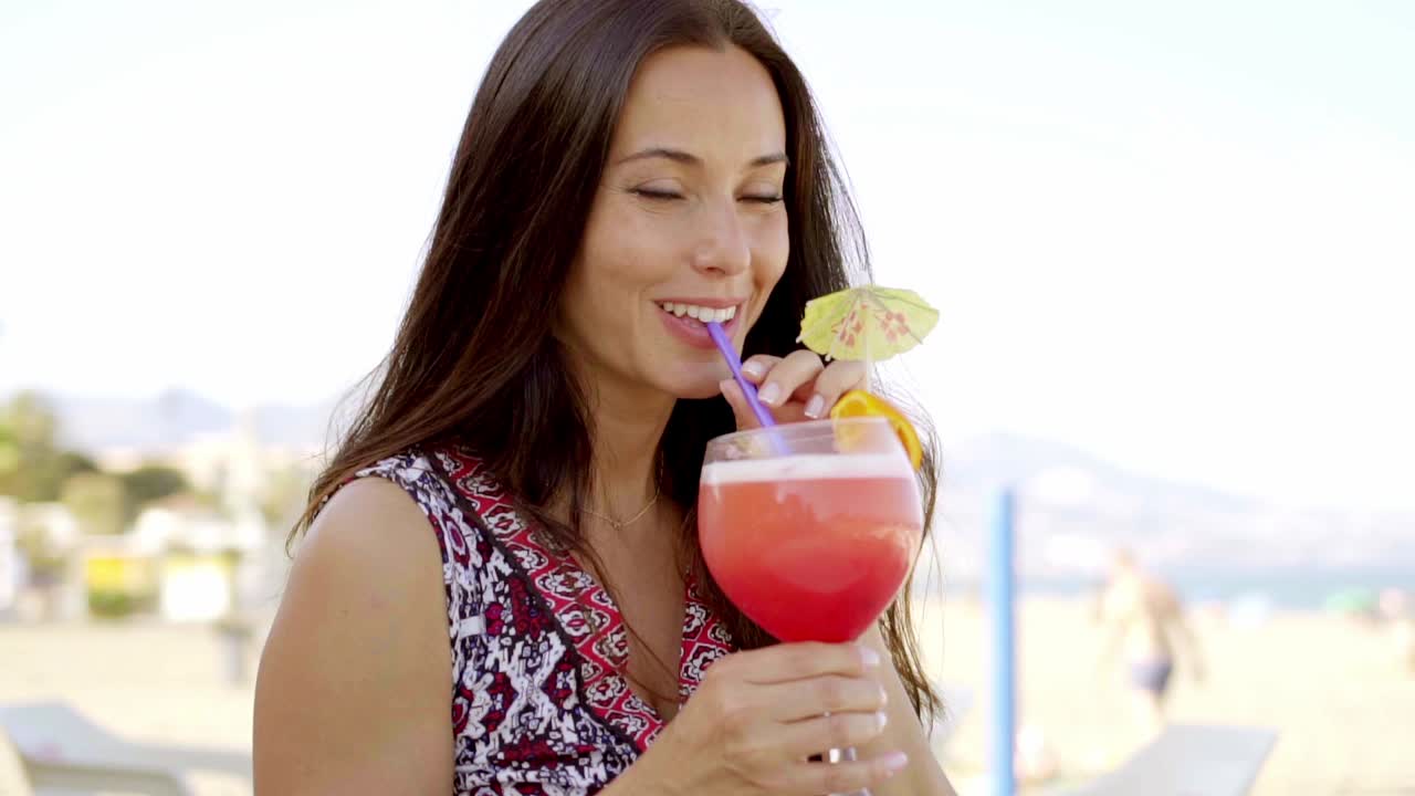 una joven hermosa disfrutando de un cóctel.