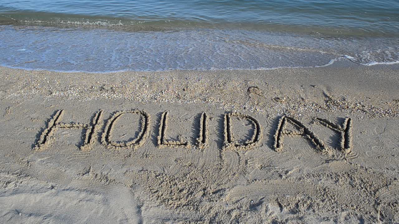 De inscriptie Vakantie op zand. Inscriptie op zand