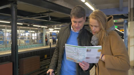 couple of travelers with map in subway