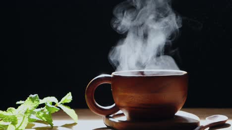 the hot tea in the wooden cup has white smoke.