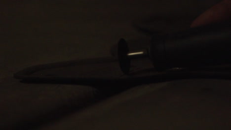 a small rotary tool cuts through a metal frame with sparks flying.