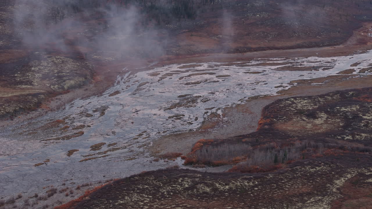 Ogilvie River Flowing Along The Mountain And Forest On A Foggy Morning In Yukon, Canada. Aerial Drone Shot