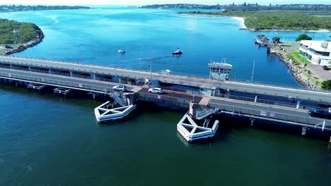 Paisaje-De-Automóviles-Circulando-Sobre-El-Puente-Principal-De-La-Ciudad-En-Swansea,-Suburbio-De-Belmont,-Lago-Macquarie,-Canal-De-Entrada,-Vía-Fluvial,-Australia,-Infraestructura-Aérea-De-Drones