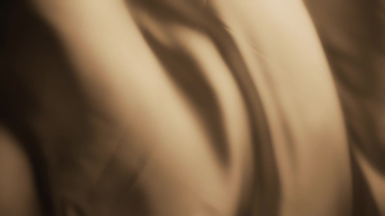 Tessuto di seta beige che ondeggia al vento. Sfondo con texture astratta.