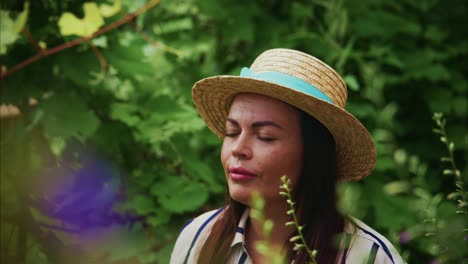 woman in straw hat enjoying nature surrounded by vibrant flowers and lush greenery