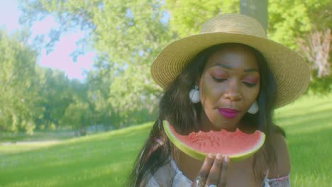 Schwarze-Frau,-Die-Beißende-Wassermelonen-Isst-Und-An-Einem-Sonnigen-Tag-Ein-Picknick-Im-Park-Genießt