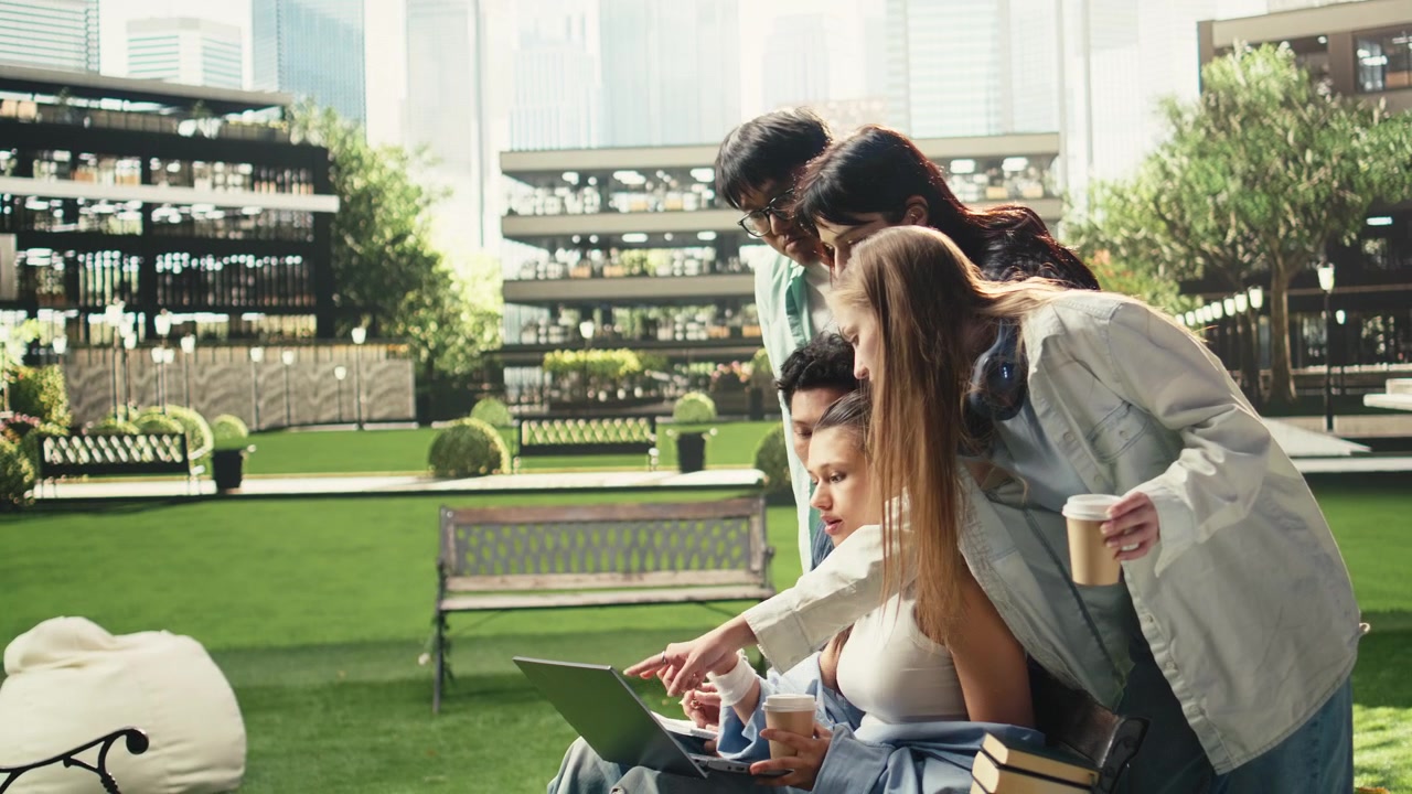 Classmates sitting on campus benches for quiet study with laptop and books,