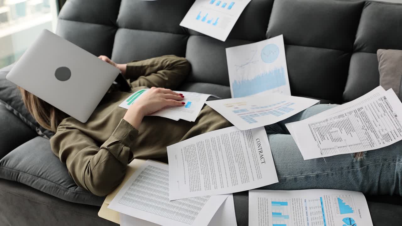 Woman Overwhelmed by Work and Documents, Lying on Couch