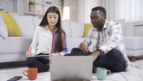 African-college-student-young-man-and-caucasian-young-woman-studying-at-home,-preparing-for-exams.