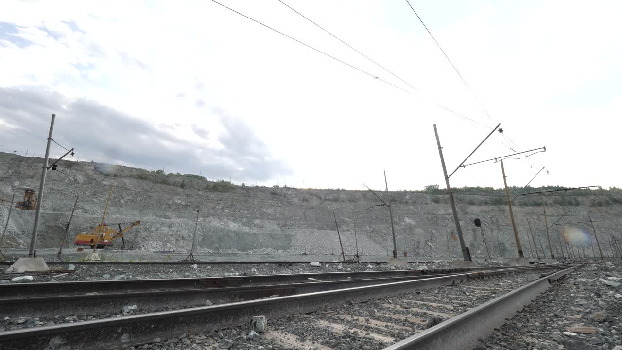 cantera con vías ferroviarias y excavadora