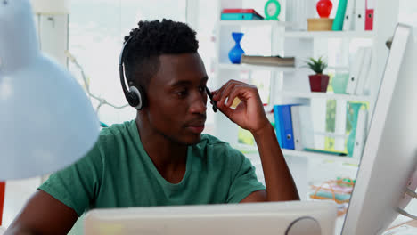 Male-customer-service-executive-talking-on-headset-at-desk-4k