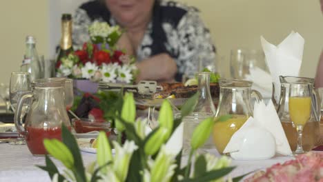 grupo de amigas mayores comiendo y bebiendo juntas en la mesa de cena