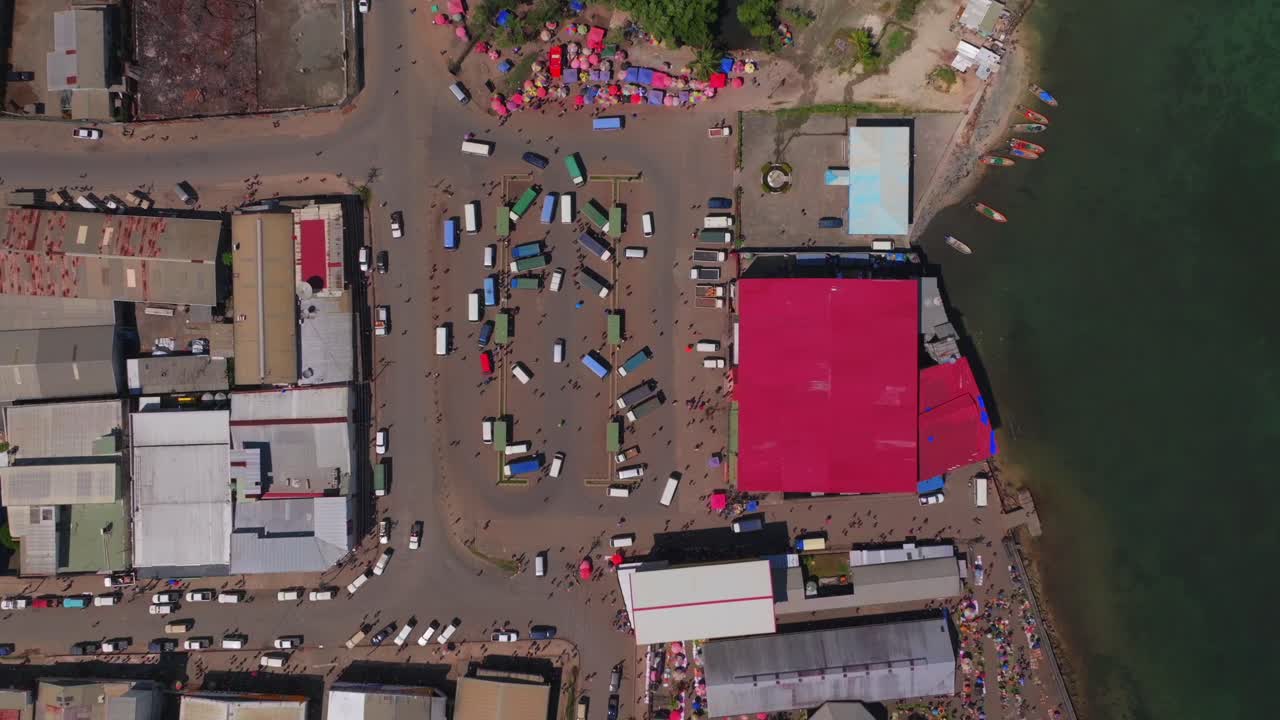 Wewak Sundaun fish Market Wewak Hill buildings cars buses traffic people boats Papua New Guinea aerial drone downtown coastal town coastline beach Dogreto Bay sunny morning colorful umbrellas static