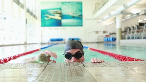 fit man swimming in swimming pool